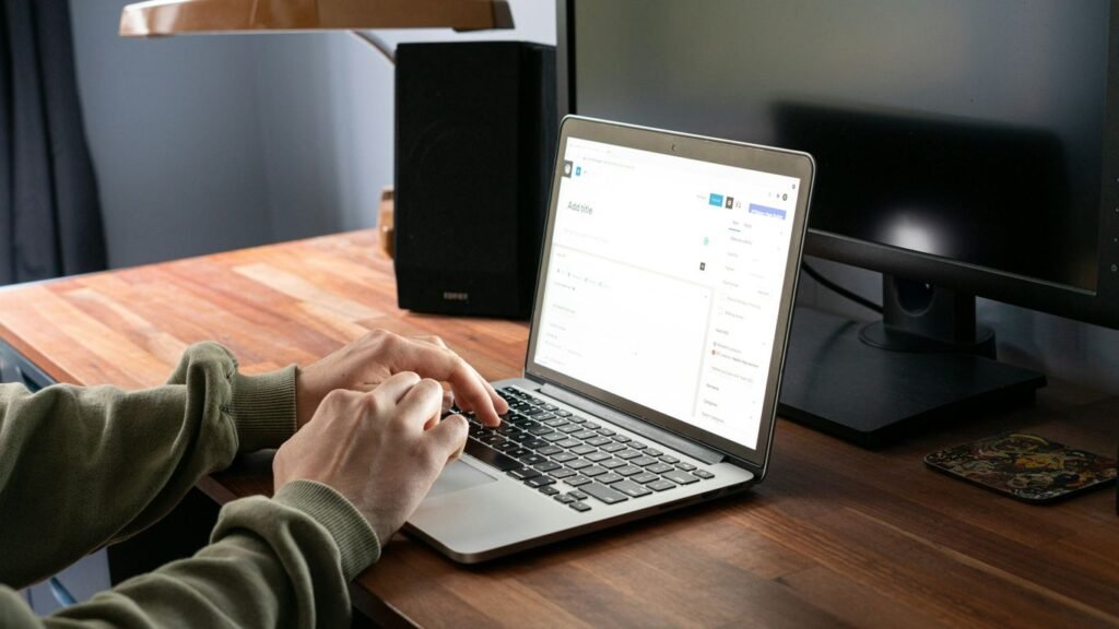 person in gray jacket using macbook pro
