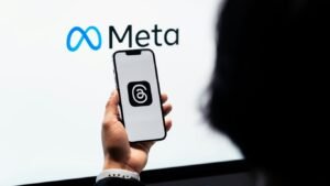 a person holding a cell phone in front of a large screen