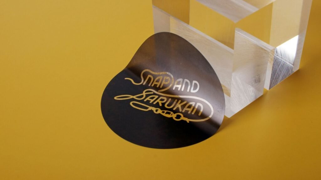 A black sticker with gold text sits near object.