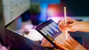 Person using stylus on tablet with charts.