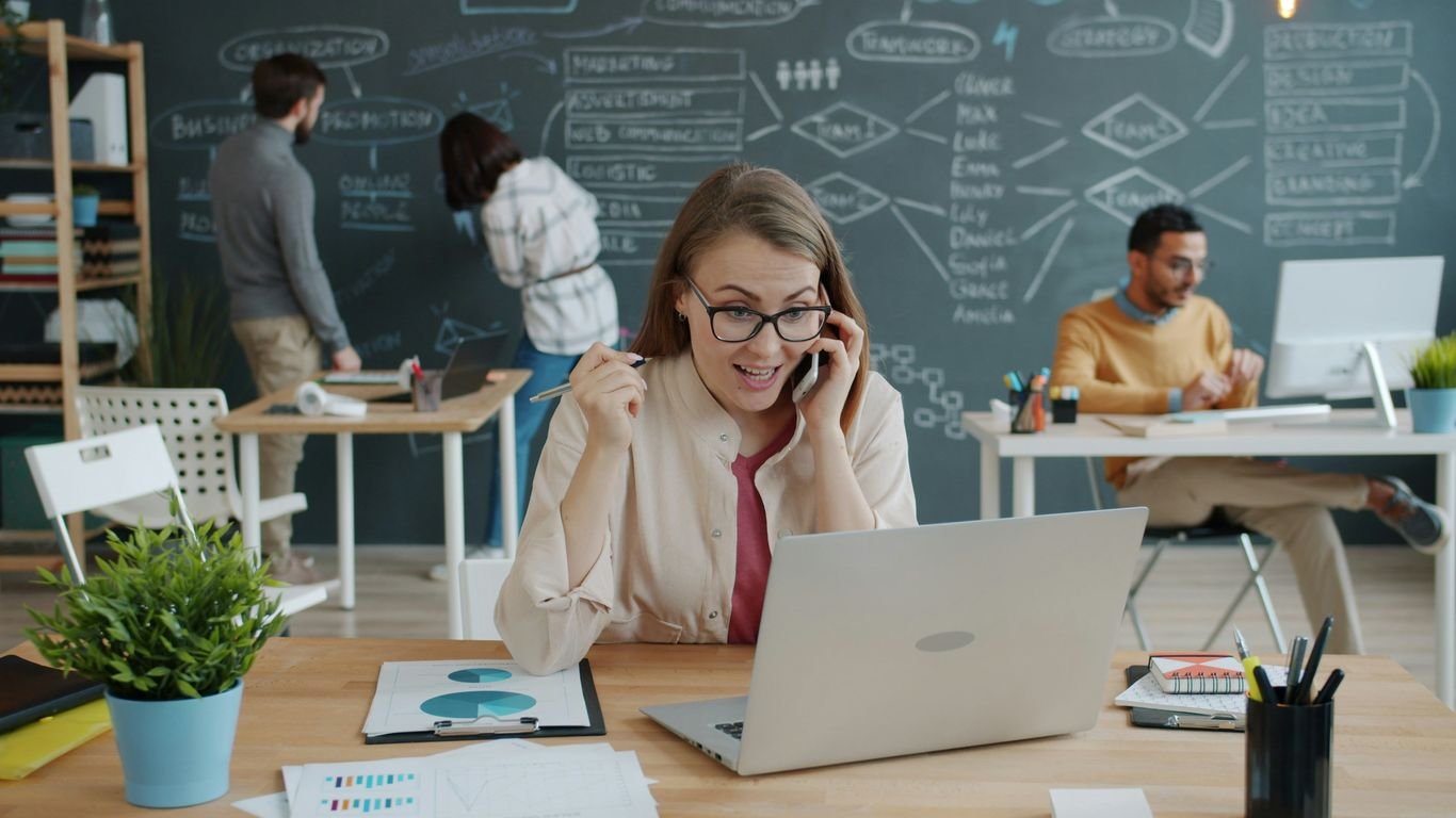 Woman celebrating success while on a business call.