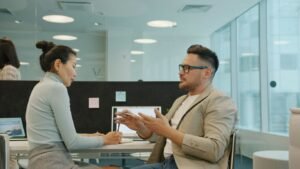Two colleagues discussing work in a modern office.