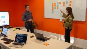 a man and a woman standing in front of a whiteboard
