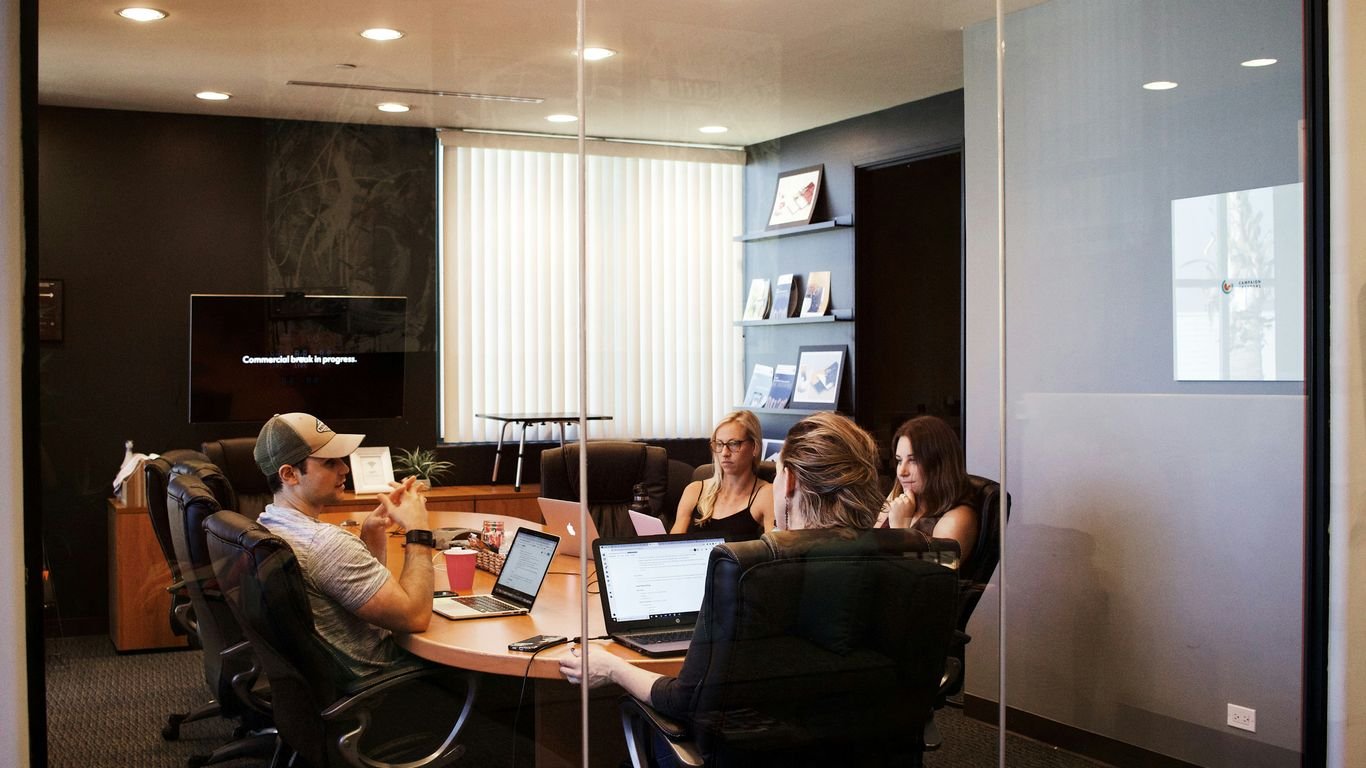 people sitting near table with laptop computer