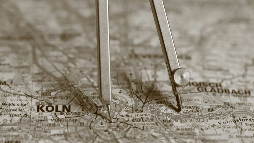 A compass resting on a map with "koln" visible.