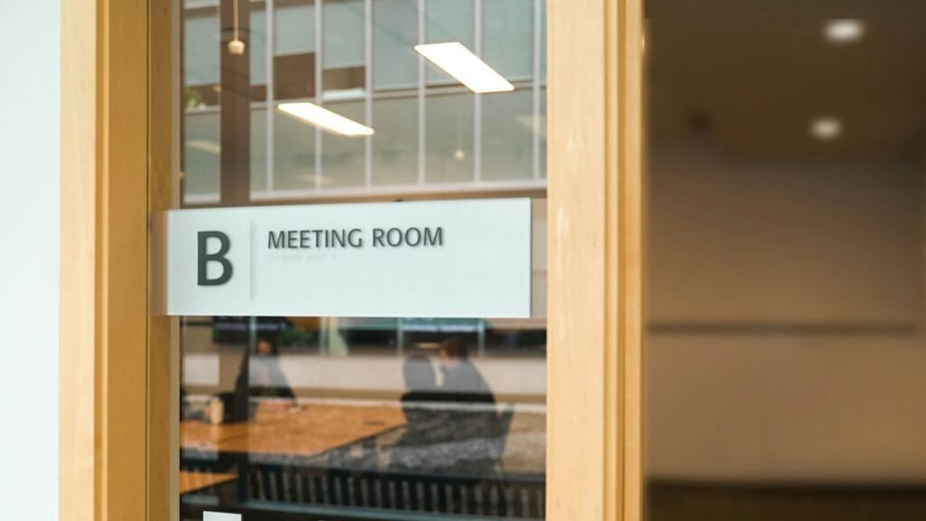a sign on a glass door that says meeting room