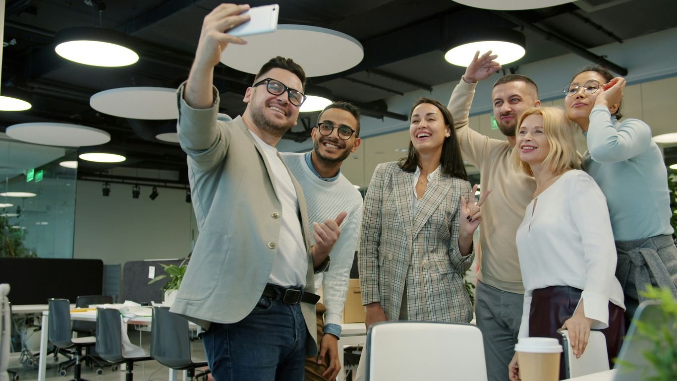 Group of colleagues taking a selfie in the office.