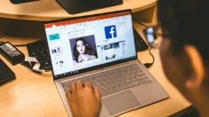 person using laptop browsing facebook application
