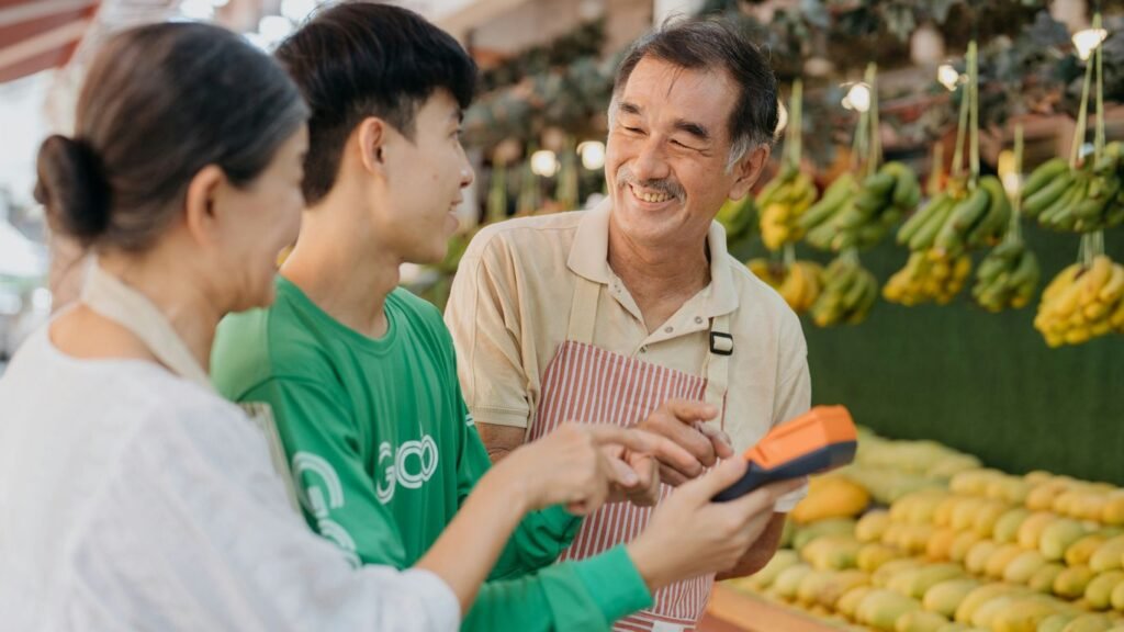 a couple of people standing in front of a fruit stand