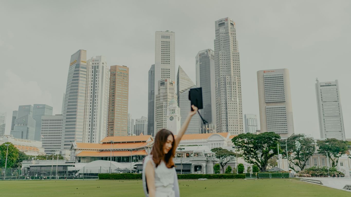 a woman in a white dress holding up a black object in front of a city