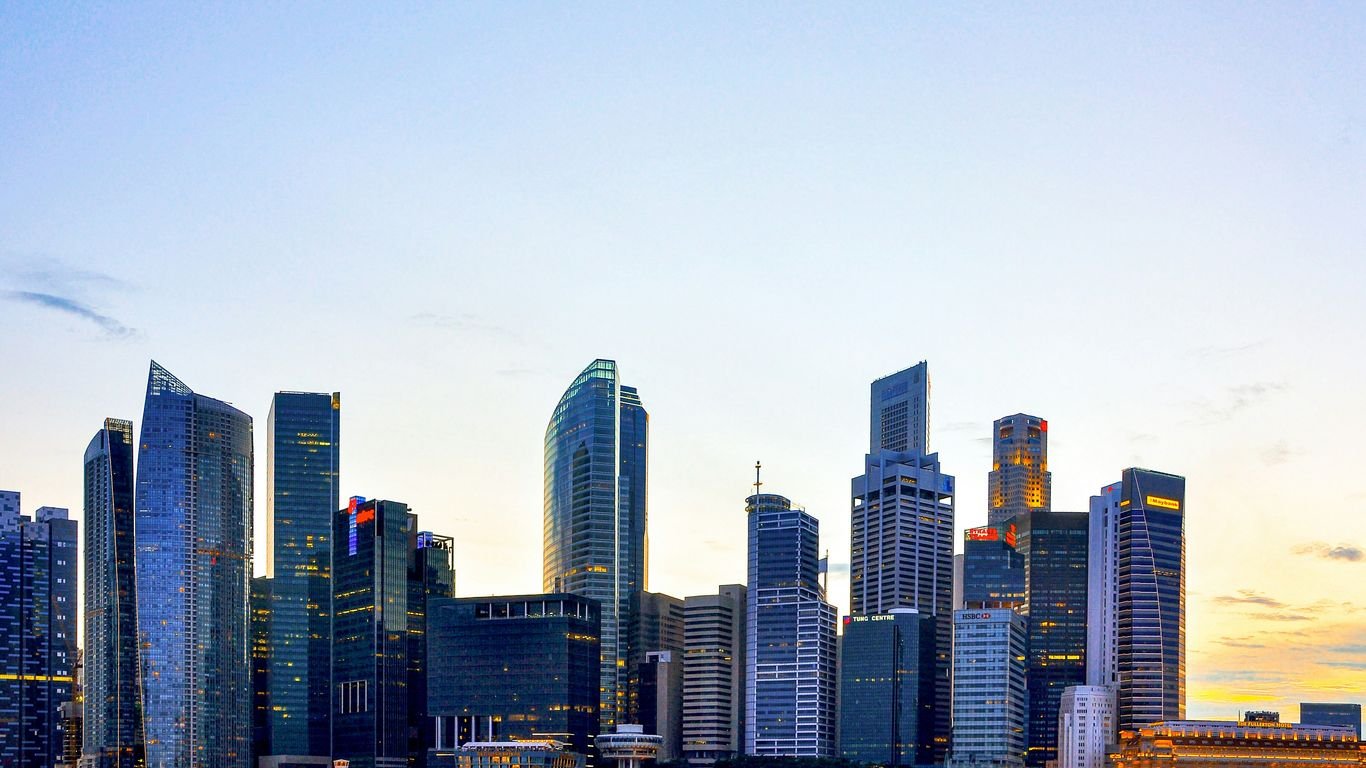 a city skyline with tall buildings and a body of water