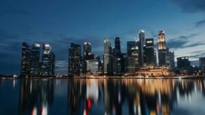 city skyline across body of water during night time