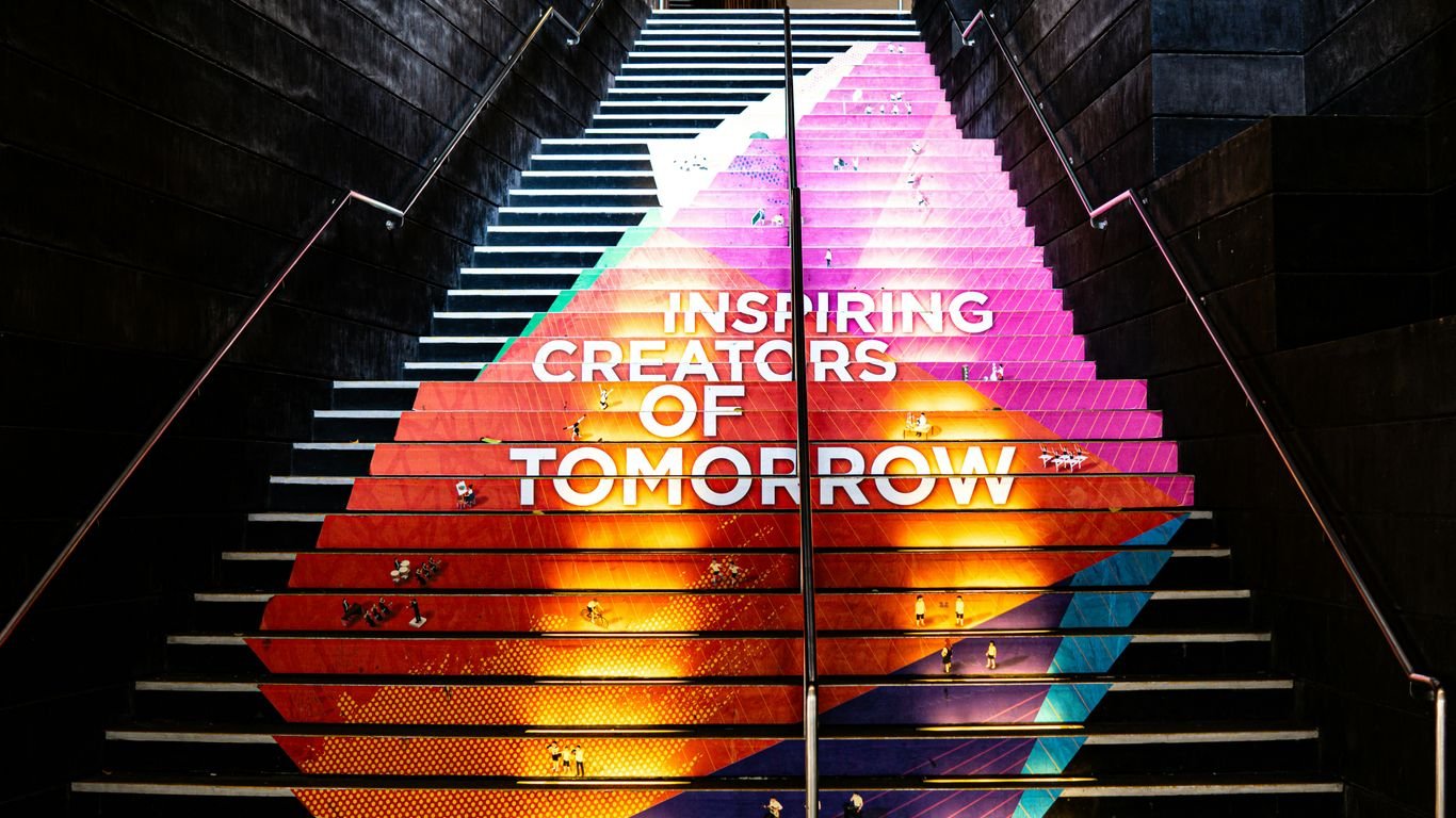 A stair case with a painting on the side of it