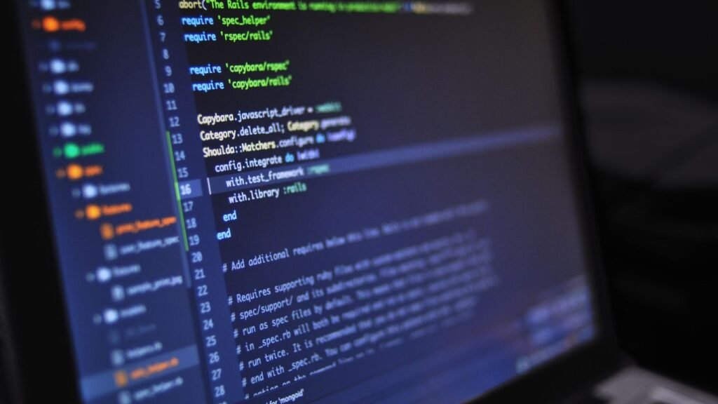 Solo freelance WordPress developer working at a laptop beside a Singapore web design agency team reviewing a site build together