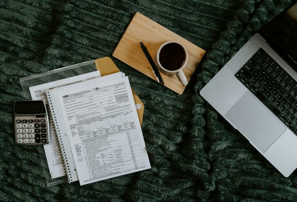 Laptop, calculator and papers laid out while a Singapore SME owner works out digital marketing costs for their business