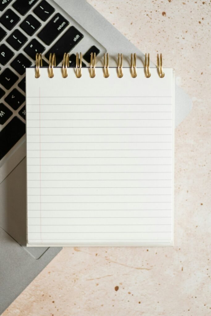 Notepad open on top of a laptop, representing a Singapore business planning its content marketing