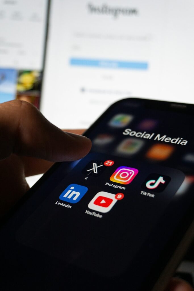 Hand holding a smartphone with a social media app open, representing a Singapore business choosing the best platform for its audience
