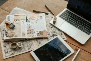 iPad, laptop and book side by side representing a Singapore SME weighing content marketing against traditional marketing channels