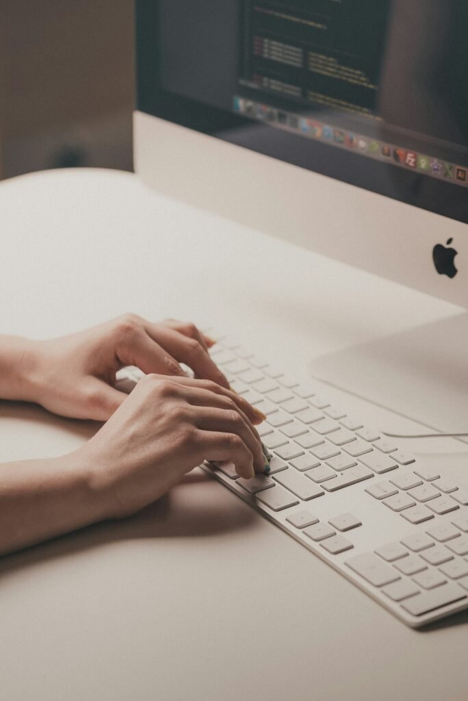 Person typing on a computer keyboard while writing an SEO blog post for a Singapore business
