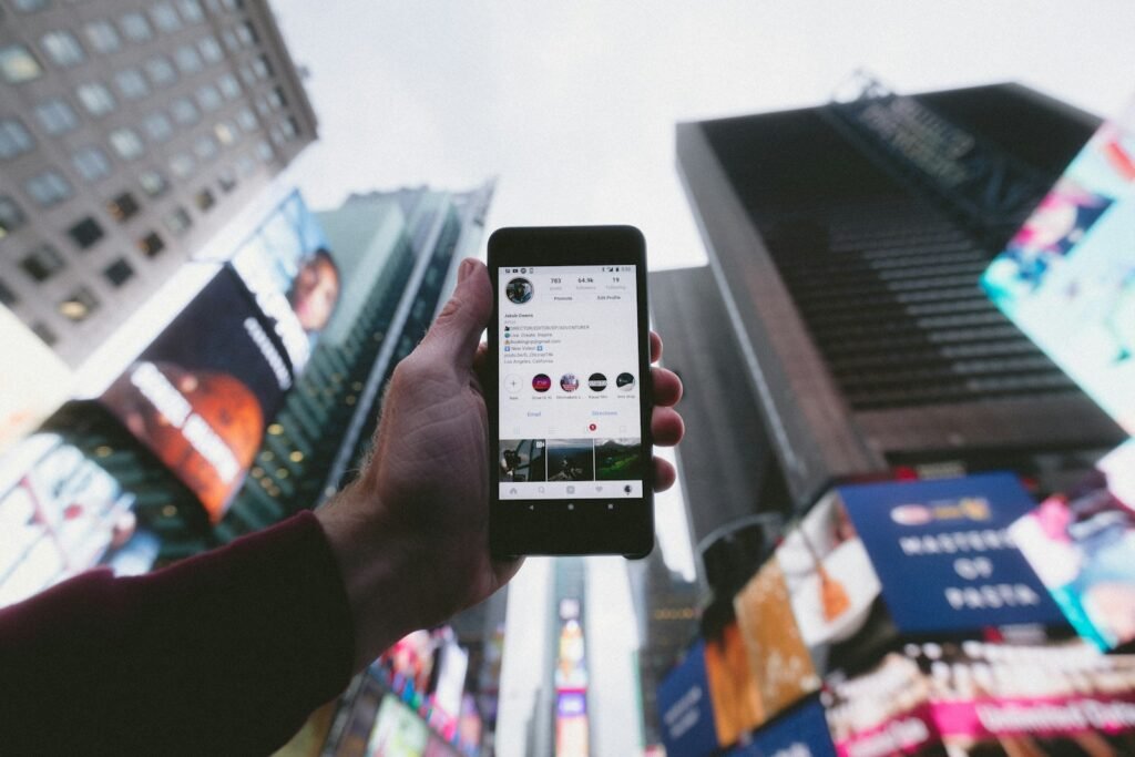 Smartphone showing social media in a busy city, representing social media advertising
