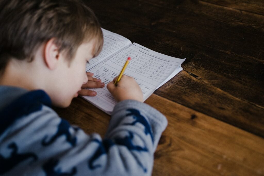 Child writing at a desk during a tuition lesson