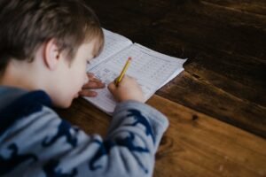 Child writing at a desk during a tuition lesson