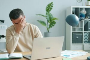 Frustrated business owner at a laptop, representing common digital marketing mistakes