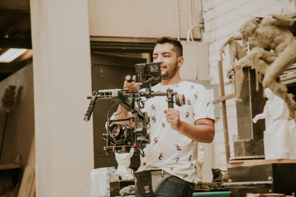 A corporate video producer checks the call sheet and schedule on set while the crew films an interview in the background.