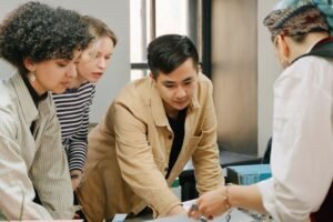 A marketing manager reviews printed layout options with a designer from a creative design agency Singapore businesses use for website and brand work.