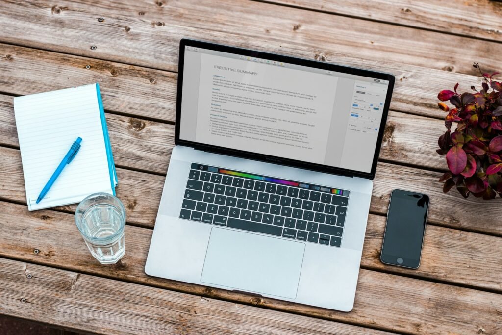 Laptop, notebook and coffee on a desk, representing learning digital marketing basics