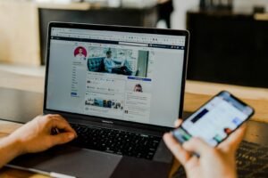 Marketer managing Facebook advertising on a laptop and smartphone