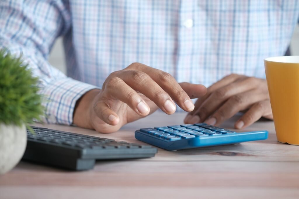 Hands using a calculator, representing how marketing agencies price their services