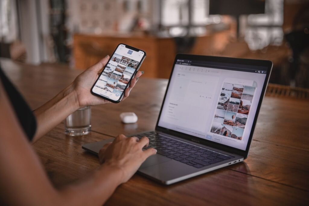 A social media manager reviewing campaign results on a phone and laptop while working with a Facebook marketing partner in Singapore.