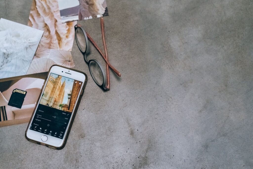 A designer adjusting image dimensions on a smartphone while preparing Instagram image sizes for Singapore campaigns.