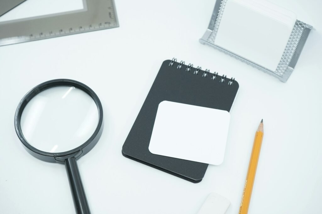 Magnifying glass and notebook, representing keyword research