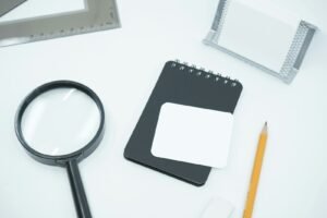 Magnifying glass and notebook, representing keyword research