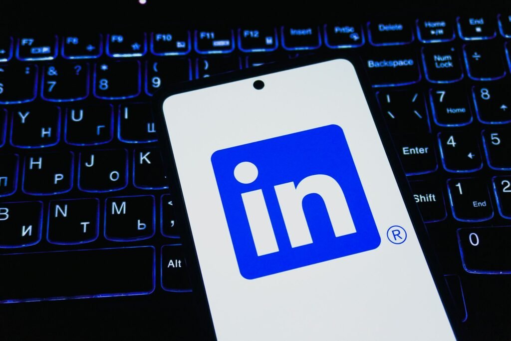 LinkedIn app on a smartphone resting on a laptop keyboard