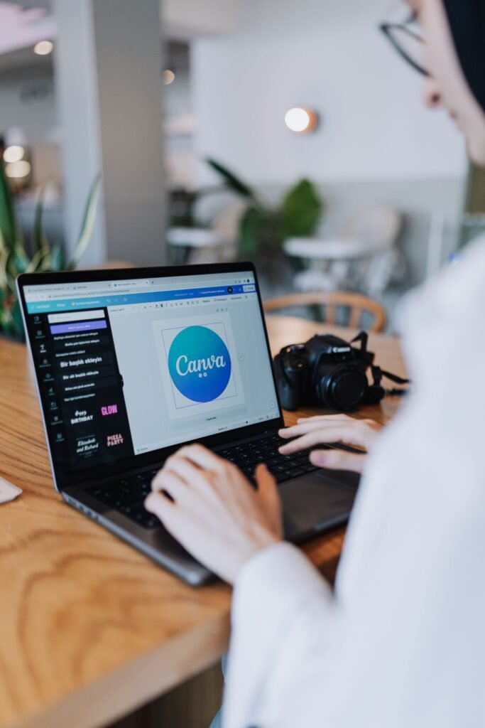 Designer creating a logo concept for a Singapore SME using design software on a laptop.