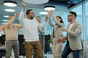 Marketing team celebrating a win in the office, showing marketing momentum