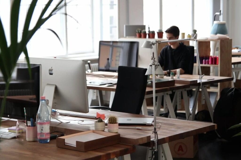 An SEO copywriter in Singapore drafting page copy while reviewing search results and a keyword list on a second screen.