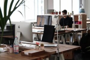 An SEO copywriter in Singapore drafting page copy while reviewing search results and a keyword list on a second screen.