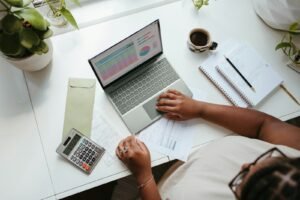 Business owner planning an SEO services budget with a laptop and calculator