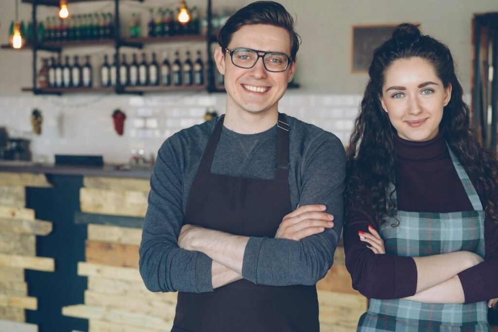 Small business owners standing in their cafe, representing SEO services for SMEs