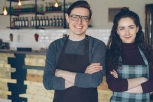 Small business owners standing in their cafe, representing SEO services for SMEs