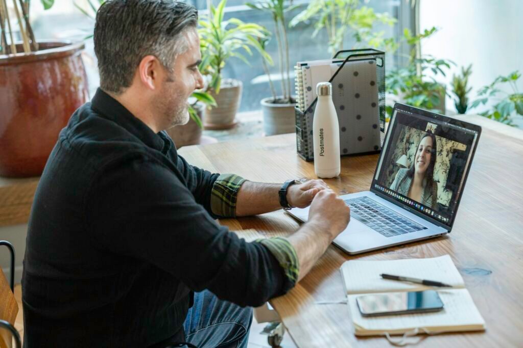 Business owner on a video call with a remote team, representing outsourced SEO