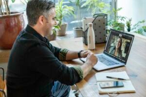 Business owner on a video call with a remote team, representing outsourced SEO