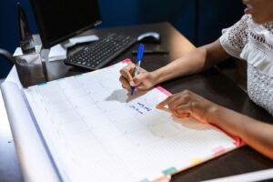 A marketing team in a Singapore office reviewing a printed content calendar while planning a social media campaign Singapore brands will run for the next quarter.