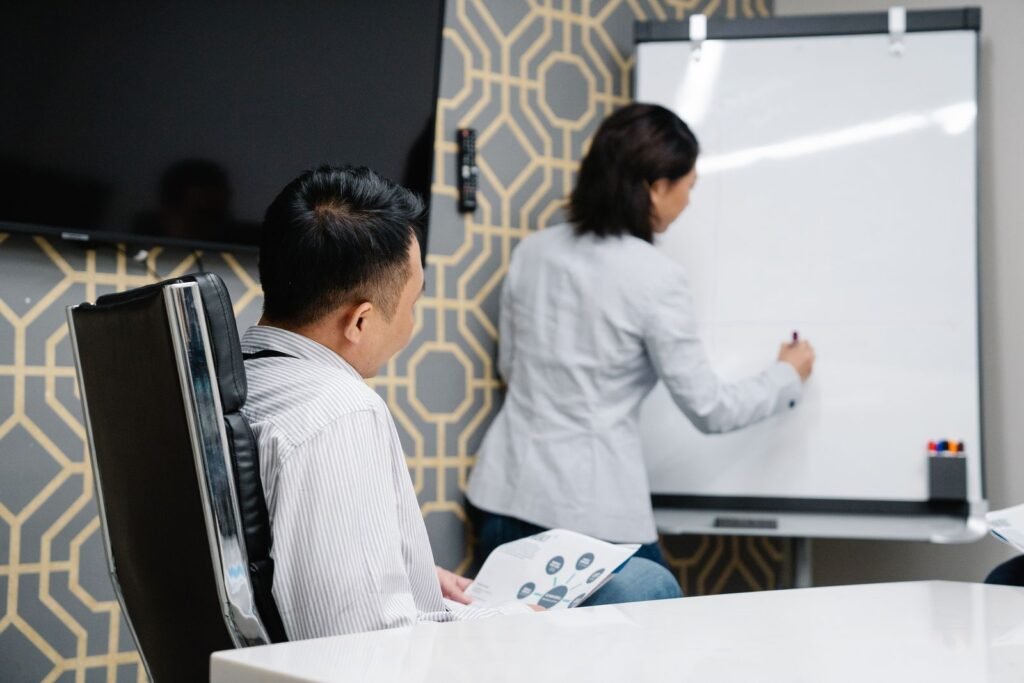 A marketing team mapping strengths and weaknesses on a whiteboard during a SWOT analysis in Singapore.