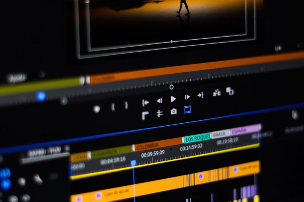 An editor working on a timeline at a dual-monitor suite in a video editing company Singapore studio with handwritten timecode notes beside the keyboard.