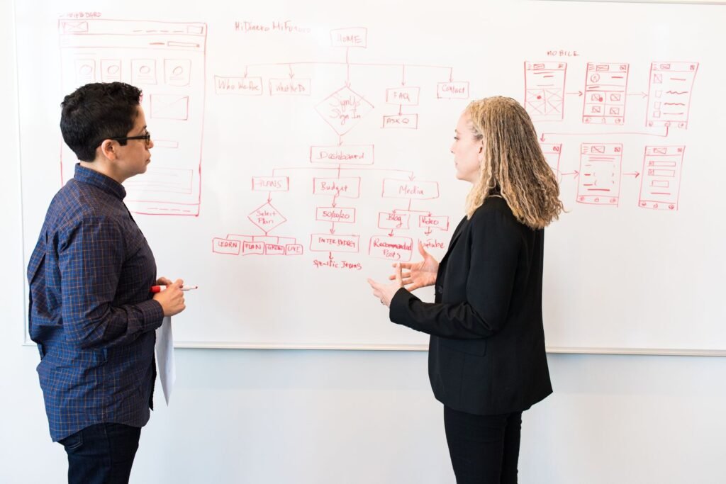A business owner and a developer reviewing a staging site together during a handover meeting with a web agency Singapore SMEs use for their website build.